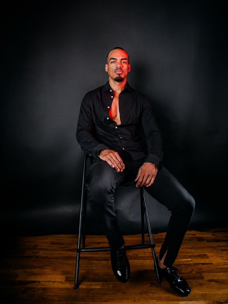 Portrait of Jariel seated against a dark background