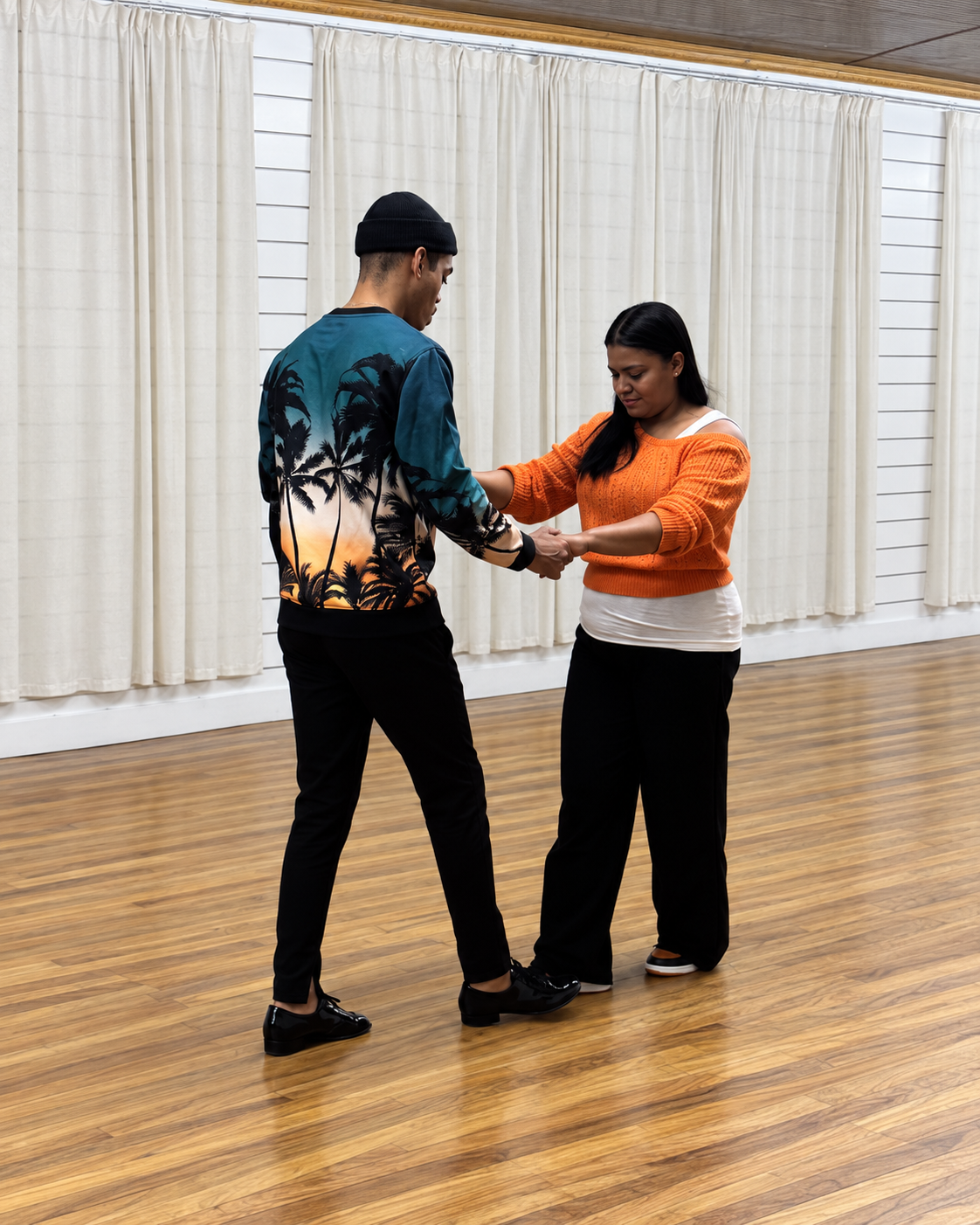 Jariel guiding a student through a salsa step